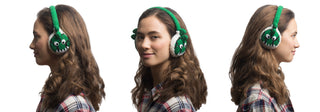 A young woman with wavy brown hair wears green earmuffs with monster faces. She is shown in three angles: left profile, front, and right profile, all against a white background.