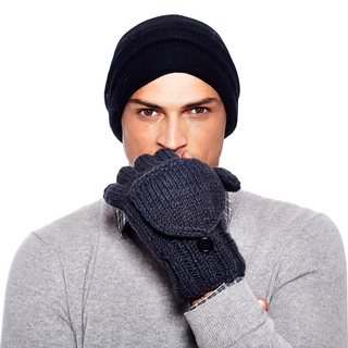 A person wearing a black knit hat, a gray sweater, and dark gray Fingerless Gloves With Button Flap and Fleece Lining is in the image. The person holds their mitten-covered hand near their face against a plain white background.