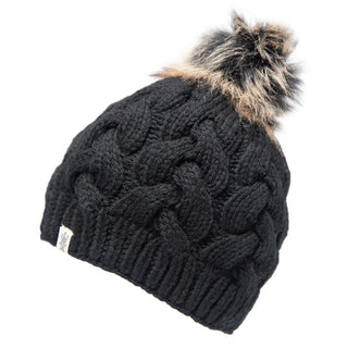 The Boheme Cable Beanie w/ Faux Fur Pom is a black, knitted winter hat featuring a large, fluffy faux fur pom-pom on top. Made from 100% Merino Wool, it showcases a cable knit pattern and includes a small tag on the cuff.