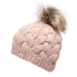 Introducing the Boheme Cable Beanie w/ Faux Fur Pom, a light pink, thick knitted winter hat with a chunky cable knit pattern. Crafted from 100% Merino Wool, this beanie features an attached brown faux fur pom-pom on top and a small beige tag with an emblem near the ribbed bottom edge.