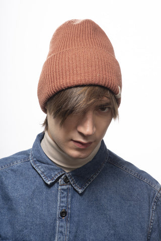 A young man wearing a brown Troubadour Rib Fold Beanie.