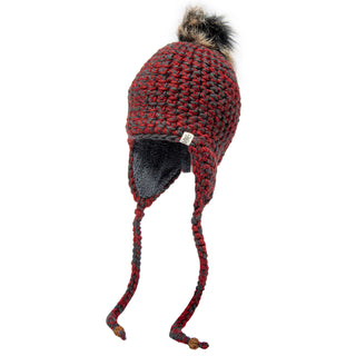 The Chunky Knit Earflap Hat, made from soft Merino wool, showcases a lively red and black design with braided tassels and a fluffy pom-pom adorning the top.