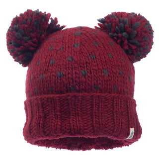 Introducing the Double Pom Kira Hat, a delightful red knitted beanie handcrafted in Nepal from soft wool. It features two large pom-poms on top, a folded brim, and is elegantly adorned with a subtle pattern of scattered gray dots.