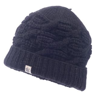The Side Cable Knit Beanie, handmade in Nepal from 100% wool, boasts a dark color with a slightly textured cable knit pattern and a folded brim. It features a small rectangular fabric label on the brim. Made of thick material, this beanie is perfect for cold weather.