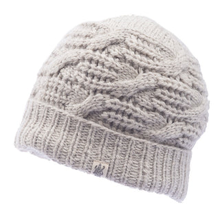 The Side Cable Knit Beanie, handmade in Nepal from 100% wool, is a light gray hat featuring a cable knit design and a ribbed bottom edge. A small tag with an emblem is attached to the front for added detail.