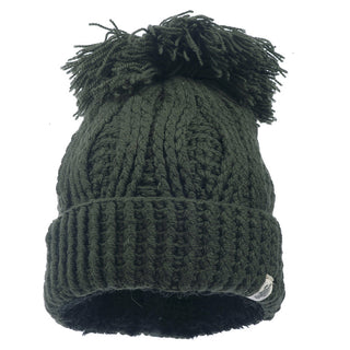The Big Pom Rib Fold Hat is a dark green, handmade knitted beanie from Nepal. It features a thick ribbed fold-over cuff, a large pom-pom on top, and a textured cable knit pattern. This beanie is crafted from 100% merino wool.