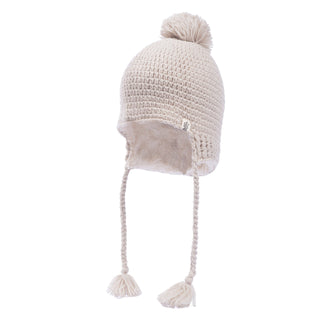 The Verona Earflap Hat is a beige knitted winter hat featuring wool earflaps, braided tassels, and a pom-pom on top. Expertly handmade in Nepal, it includes a soft sherpa lining for added warmth.