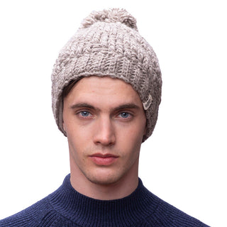 A man wearing a hand-knitted swirl pom beanie.