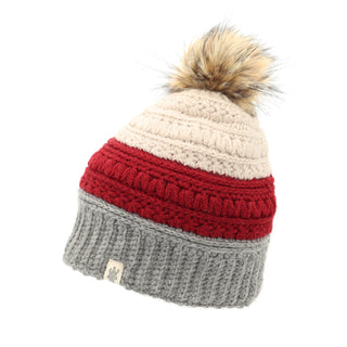 Introducing the Stripe Flower Fur Pom Pom: a chic, knitted winter hat with a faux fur pom-pom on top. This stylish accessory features a color scheme of beige, red, and gray sections from top to bottom. The gray band at the bottom is adorned with a small white tag featuring the logo.