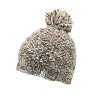 Introducing the Chunky Pom, a knitted beanie hat crafted with green and gray yarn. It features a playful pom-pom on top, a textured chunky knit pattern, and a small fabric tag with a logo near the brim.