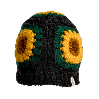 The Sunflower Hat is a handmade black wool hat featuring bold yellow and green sunflower designs on the sides, set against a simple background.