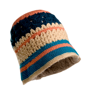 The Stripe Sun Hat is a multi-colored knit hat featuring horizontal bands in dark blue, cream, orange, and teal. Hand-knit in Nepal from soft merino wool, it boasts a textured pattern and a slightly flared brim. The background is transparent.