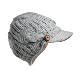 The Broadway Hat is a grey knitted cap with a visor and a stylish wooden button on the side. This winter essential boasts a ribbed texture, offers ear coverage for extra warmth, and showcases the timeless elegance of classic headwear.