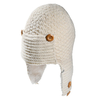 The Elk Hat is a cream-colored knit hat featuring ear flaps and a ribbed front panel, accented with brown buttons on the sides and bottom for secure wear. Its soft, cozy look makes it perfect for chilly days.