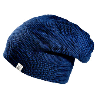 The Edgar Slouch is a dark blue knitted beanie with a slouchy design and a small rectangular tag on the rim, displayed against a white background.