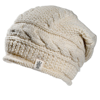 The Gateway Hat is a cream-colored, cable-knit beanie with a soft, slightly slouchy fit and features a small logo fabric tag on the brim.