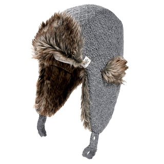 The Fern Hat is a gray knit trapper hat featuring faux fur lining, ear flaps, buttoned straps at the bottom, and a small fabric tag on one side.