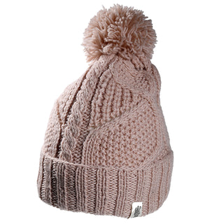 The Cedar Hat is a light pink knitted beanie featuring a cable knit pattern, ribbed cuff, large pom-pom on top, and a small white fabric tag at the bottom edge.