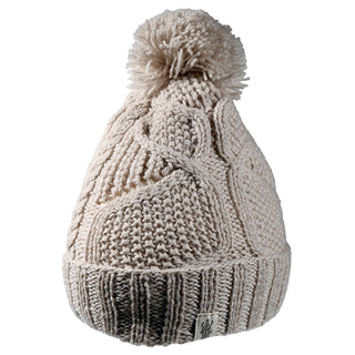 The Cedar Hat is a cream-colored knit beanie with a ribbed fold-over brim, cable pattern, large pom-pom on top, and a small fabric tag on the brim.