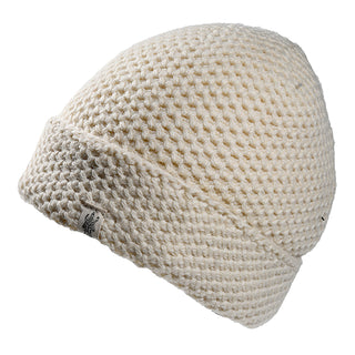 The Baltic Hat is a cream-colored, knitted beanie with a textured waffle pattern and a folded brim adorned with a small fabric tag.