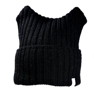 The Ely Hat, a black ribbed knit beanie with a folded brim and two pointed creases at the top for a unique shape, is displayed against a white background.
