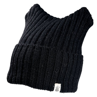 The Ely Hat is a black, ribbed knit hat with a wide folded brim, pointed corners, and a small white tag featuring a dark emblem on the brim. Shown on a white background.