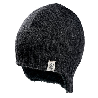 The Dakota Hat is a dark gray knit winter hat with ribbed edge, ear flaps, a small white tag with a figure, and features a soft black fleece lining for added warmth.