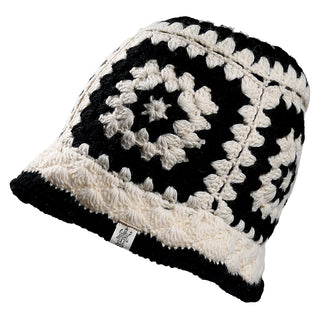 The Milie Hat is a black and white crocheted beanie with a granny square pattern and a small fabric tag on the brim.