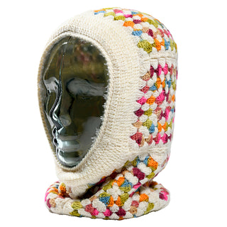 A glass mannequin head wears the Ryan Hood, a crocheted balaclava in cream with multicolored granny square patterns, covering the head, neck, and part of the shoulders.