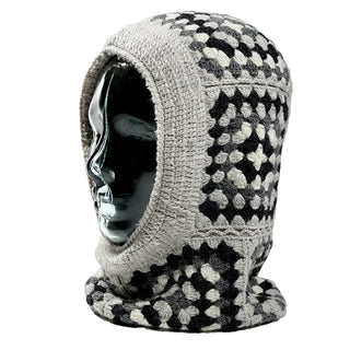 A black mannequin head displays the Ryan Hood, a crocheted balaclava in a black, gray, and white checkered pattern that fully covers the head and neck while leaving the face exposed.