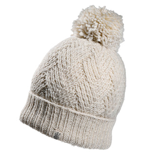 The Aspen Hat is an off-white knitted beanie with a ribbed brim, large pom-pom, textured pattern, and a small sewn tag on the brim.