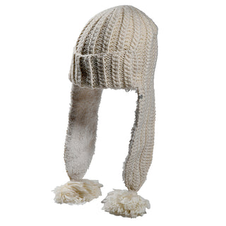 The Alex Hat is a cream-colored knit winter hat with fleece-lined ear flaps and large yarn pom-poms at the ends, shown on a white background.