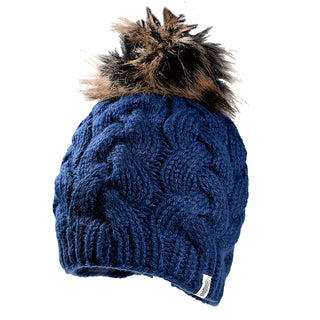 The Boheme Cable Beanie w/ Faux Fur Pom is a blue, cable-knit wool hat handmade in Nepal, featuring a textured pattern and a large brown and black faux fur pom-pom—perfect for stylish warmth on cold days.