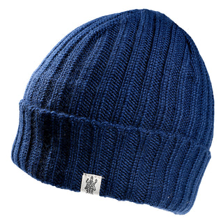 The Clyde Rib Fold Cap is a blue ribbed knit winter hat with a folded cuff and a small white patch featuring a black emblem on the front.