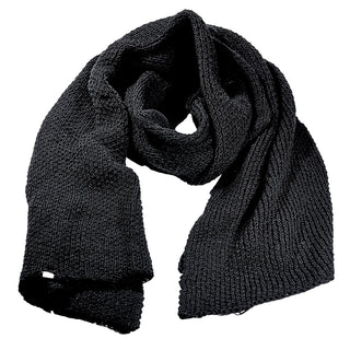 The Ithaca Scarf, a thick black knit, is displayed loosely coiled on a white background, highlighting the yarn’s texture and simple pattern.