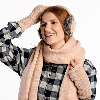 A person wearing Cable Knit Adjustable Earmuffs With Faux Fur is smiling and holding one earmuff to their ear, against a white background.