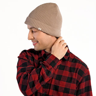 Wearing the beige Bond Hat and a red and black plaid shirt, a person stands against a white background, looking down with a slight smile while touching the back of their neck.