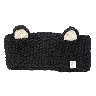 The Ears Headband is a black knitted accessory, handmade in Nepal, featuring two small white and black ears on the top. It includes a small label with a design attached to the lower right side. Made from 100% wool, the band has a thick and plush texture.