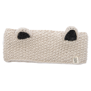 The Ears Headband is a cream-colored, knitted accessory featuring black inner ear details and two small protruding ear designs on top. Handmade in Nepal from 100% wool, this headband has a thick and cozy texture. A small tag with the logo is attached to the front right bottom corner.