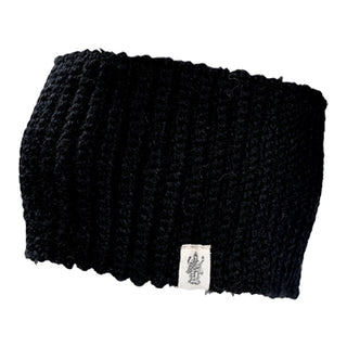 The Mandy Headband is a black, ribbed knit accessory with a small white tag featuring a simple graphic logo on the bottom edge.