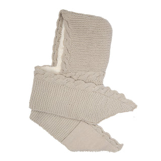 A beige "2 Pocket Scarf Hood" with a braided edge design, handmade in Nepal from soft merino wool. The scarf is folded in layers, showcasing both its textured knit pattern and the inner lining. The ends of the scarf are tapered for a refined look.