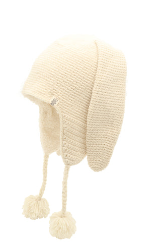 Product Name: Long Ear Puppy Hat, cream-colored and knitted, featuring extended ear flaps with braided tassels ending in pom-poms.
