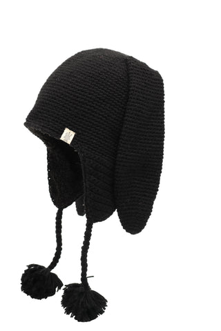 Long Ear Puppy Hat: A black knitted hat featuring long ear flaps and two dangling braids that end in pom-poms.