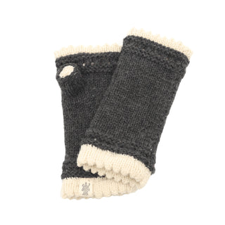 Introducing the Les Handwarmers: a pair of fingerless gray knit handwarmers adorned with white trim at both the top and bottom. A small white button accents the area near the thumb hole, complemented by a small label with a design near the cuff. Crafted from soft merino wool, these gloves are showcased laid flat, overlapping each other slightly.