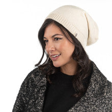 A woman wearing a cream Dekalb Slouch beanie and black coat.