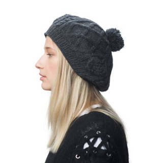 A woman wearing a Yves Beret with a pom pom.