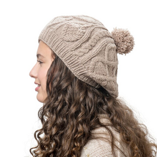 A young girl wearing a Yves Beret with a pom pom.