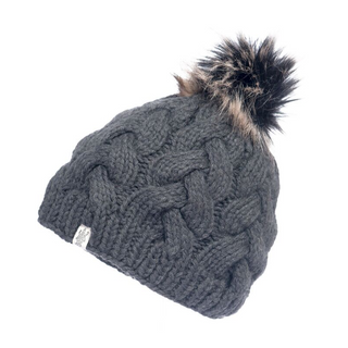 The Boheme Cable Beanie w/ Faux Fur Pom is a grey knitted winter hat made from 100% Merino Wool, showcasing a thick, braided pattern and topped with a faux fur pom-pom. It features a small white tag with an indistinguishable logo near its base, set against a white background.