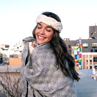 A woman wearing a gray Braided Headband on top of a building.