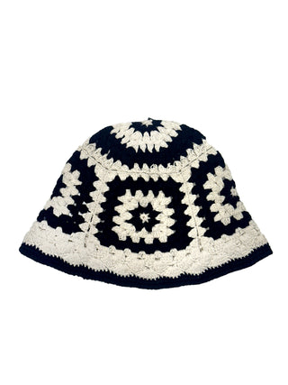 The Cotton Crochet Patch Sun Hat features a black and white geometric square pattern with alternating rows and a wide brim.